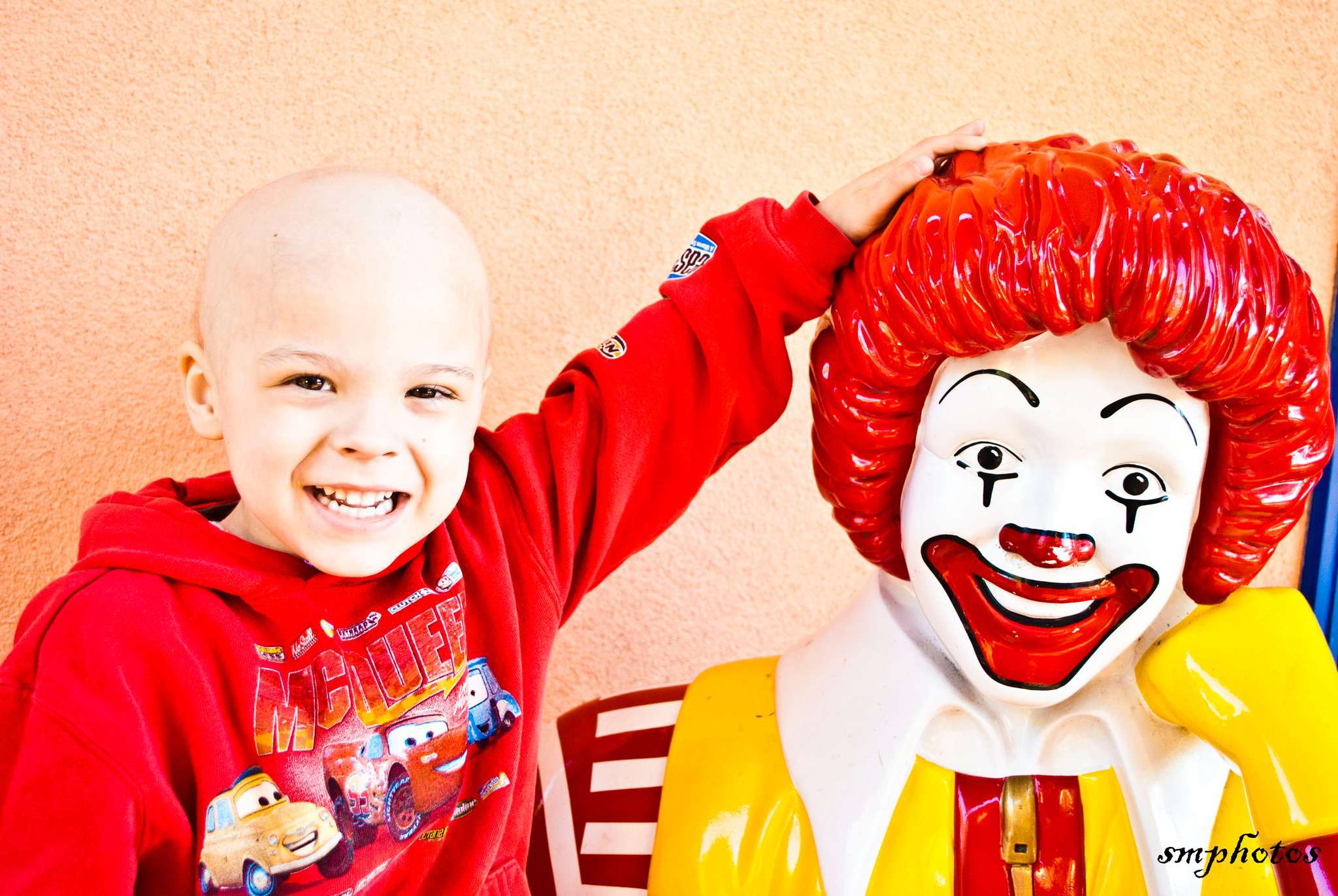 Young chemo patient posing with Ronald McDonald