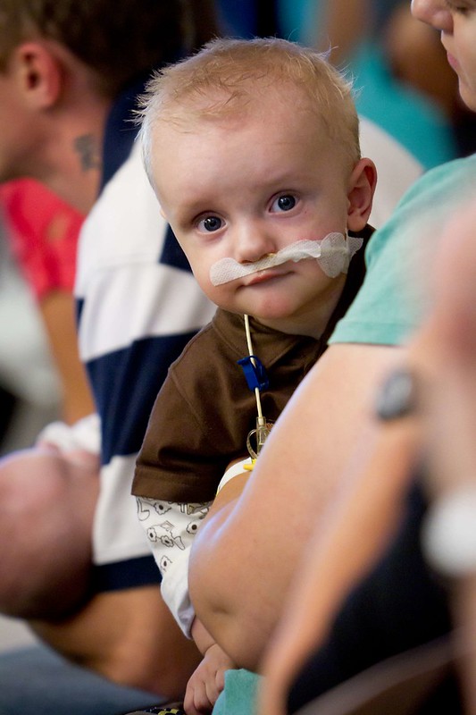 A photo of a sick baby with his family