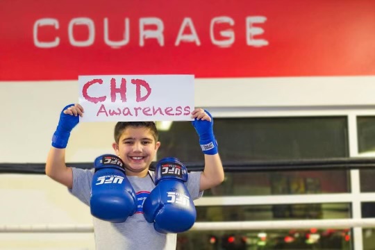 A child holding a CHD Awareness sign