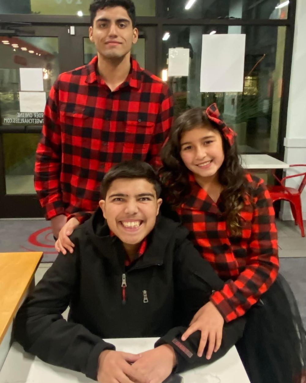 A group picture of three children smiling.