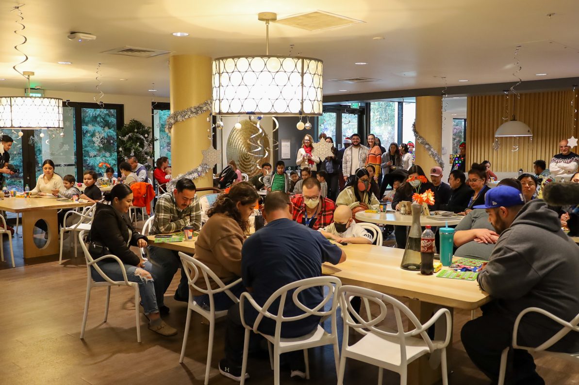 Holiday Bingo Night at RMHC Bay Area Bingo Families: Families and children gathered around decorated tables playing bingo during a festive event at RMHC Bay Area.