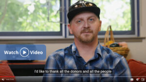 Man in plaid shirt and baseball cap thanks donors in a Ronald McDonald House Charities Bay Area video message.