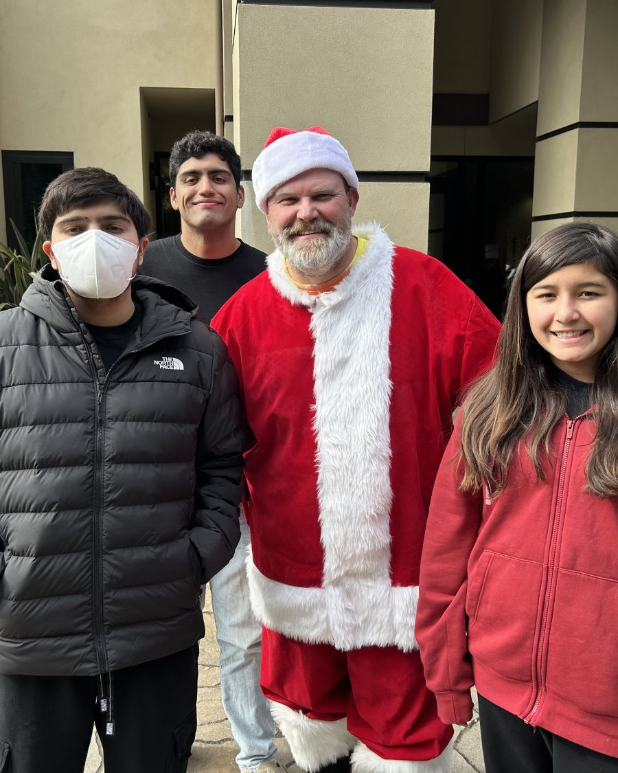 Alex and siblings outside the Arrillaga building during a holiday car show.