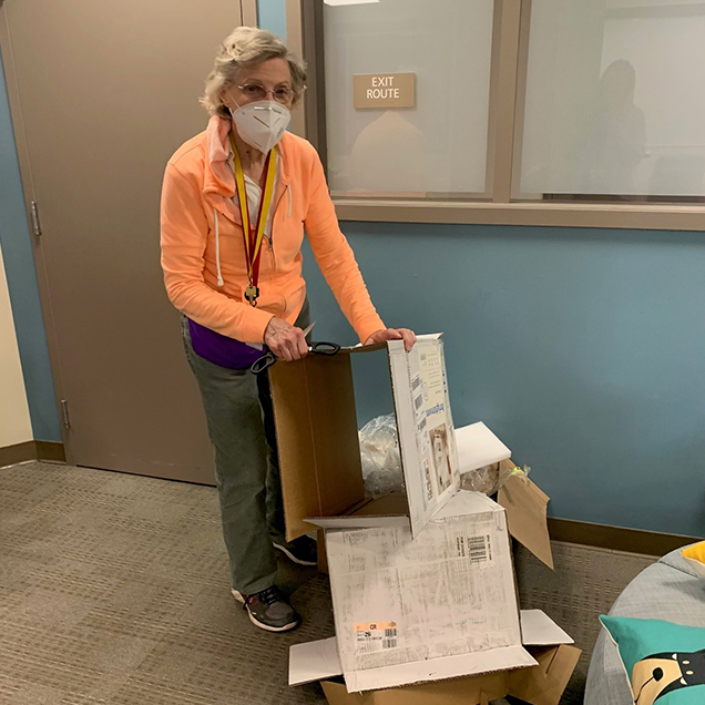 Jan Breaking Down Boxes: A Team Volunteer helping break down cardboard boxes.