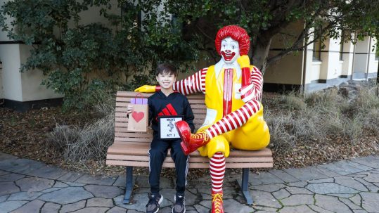 Maxx holding Valentine's kits sitting next to Ronald