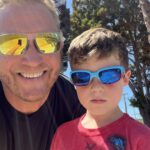 Photo of dad and son smiling with sunglasses on