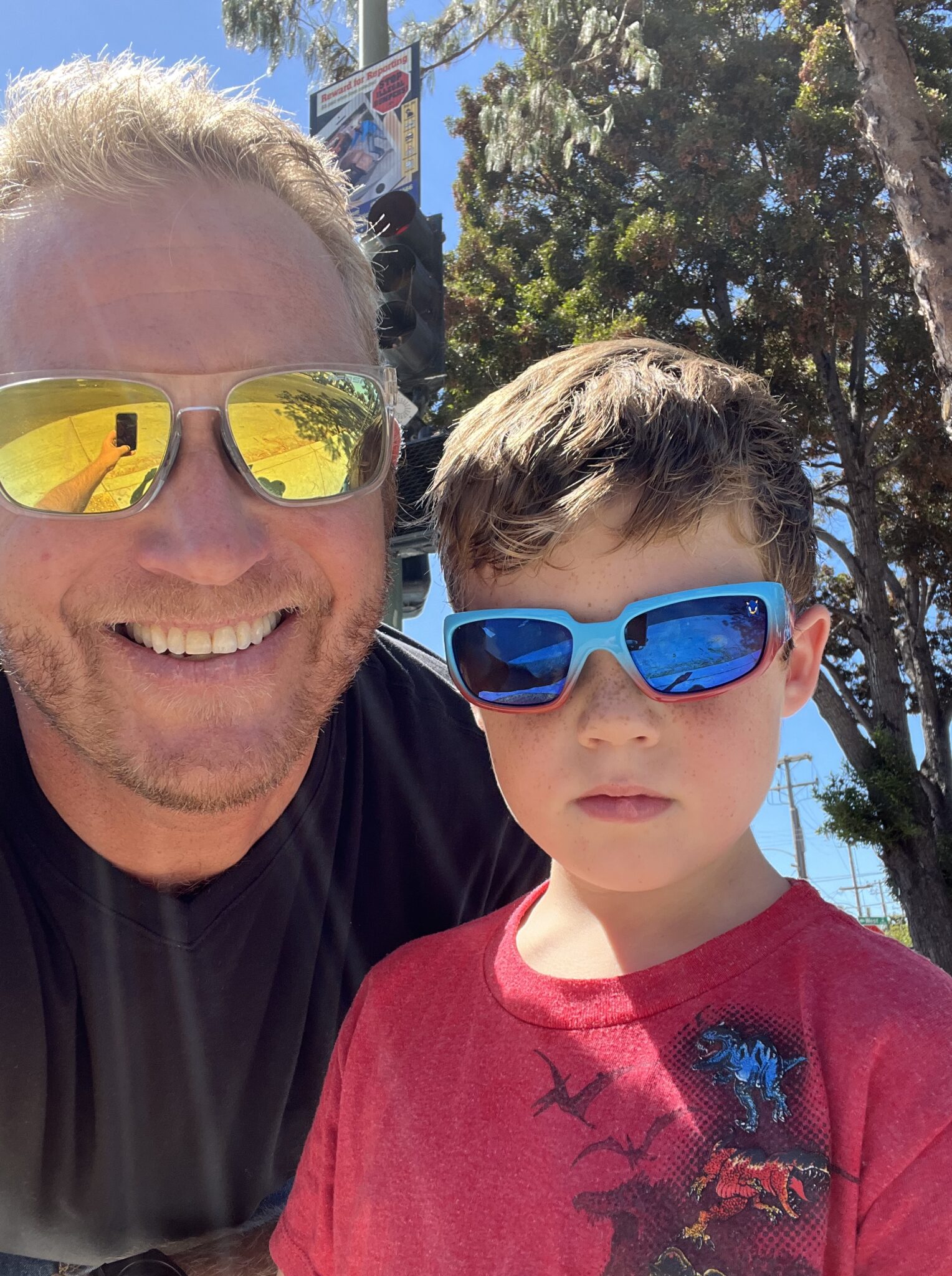 Photo of dad and son smiling with sunglasses on