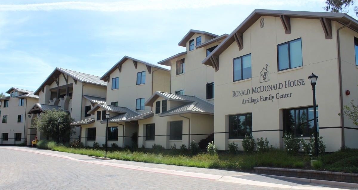 Exterior of the Ronald McDonald House at Stanford featuring beige siding, gabled roofs, and the Arrillaga Family Center name on the building.