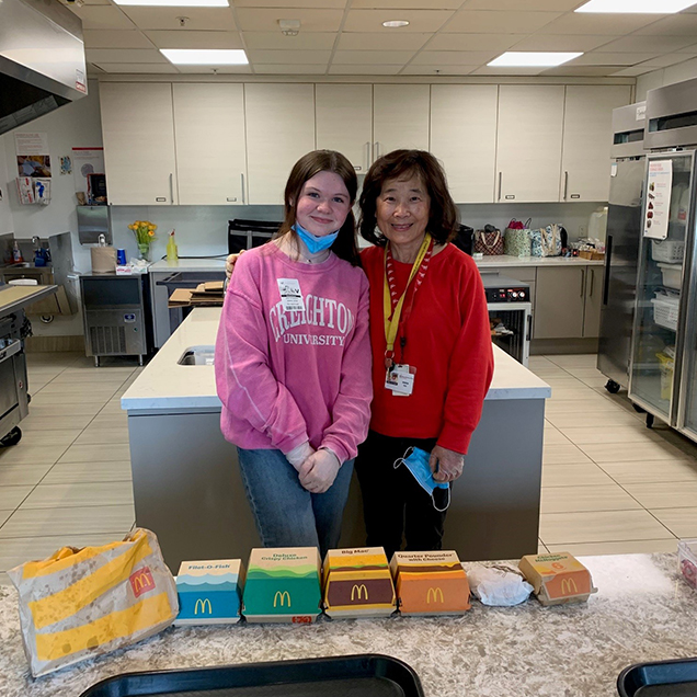 Sharon and Evelyn McDonald's Sharon and Evelyn McDonald’s: Two Special Interest Volunteers posing for a picture as they serve McDonald’s dinner to families.