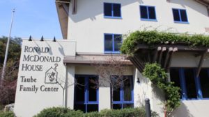 Front view of Ronald McDonald House Taube Family Center with blue windows and greenery on the facade.