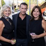 two woman and man pose with drinks