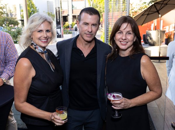 two woman and man pose with drinks