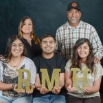 The Medina Flores family poses for a portrait holding gold glitter letters spelling RMH, as part of The Family Album Project.